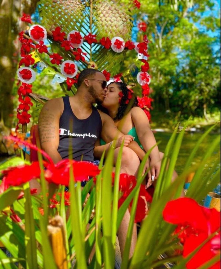 Couple sharing a kiss on a romantic Lethe bamboo rafting tour, one of the many Romantic Things to Do in Jamaica for Couples